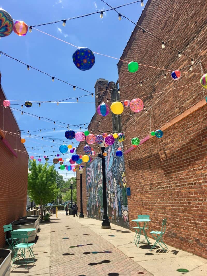 Pedestrian alley with mural, seating, and lanterns off of 9 Mile Rd in Downtown Ferndale